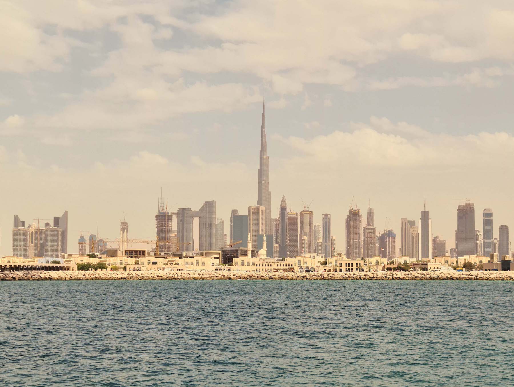 Dubai skyline and Burj Khalifa viewed from the waterfront near Sea Mirror on Jumeirah Bay Island