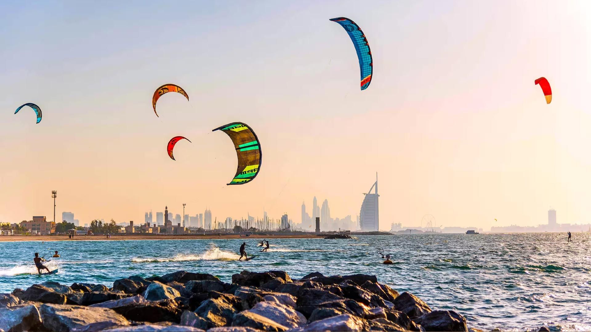 Kitesurfers off the coast with Burj Al Arab on the horizon near Jumeirah Bay Island